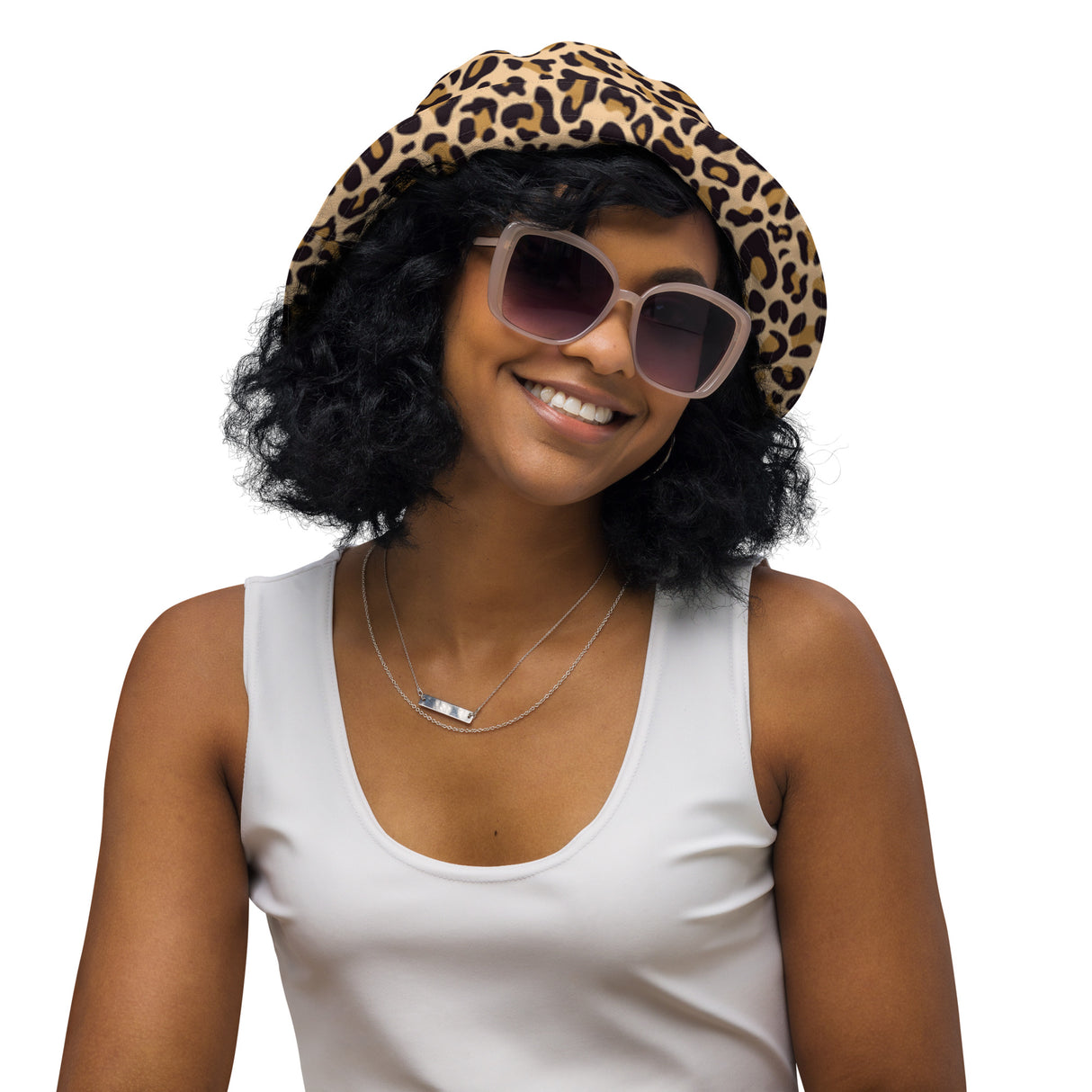 Smiling woman wearing a leopard print reversible bucket hat and sunglasses, white tank top