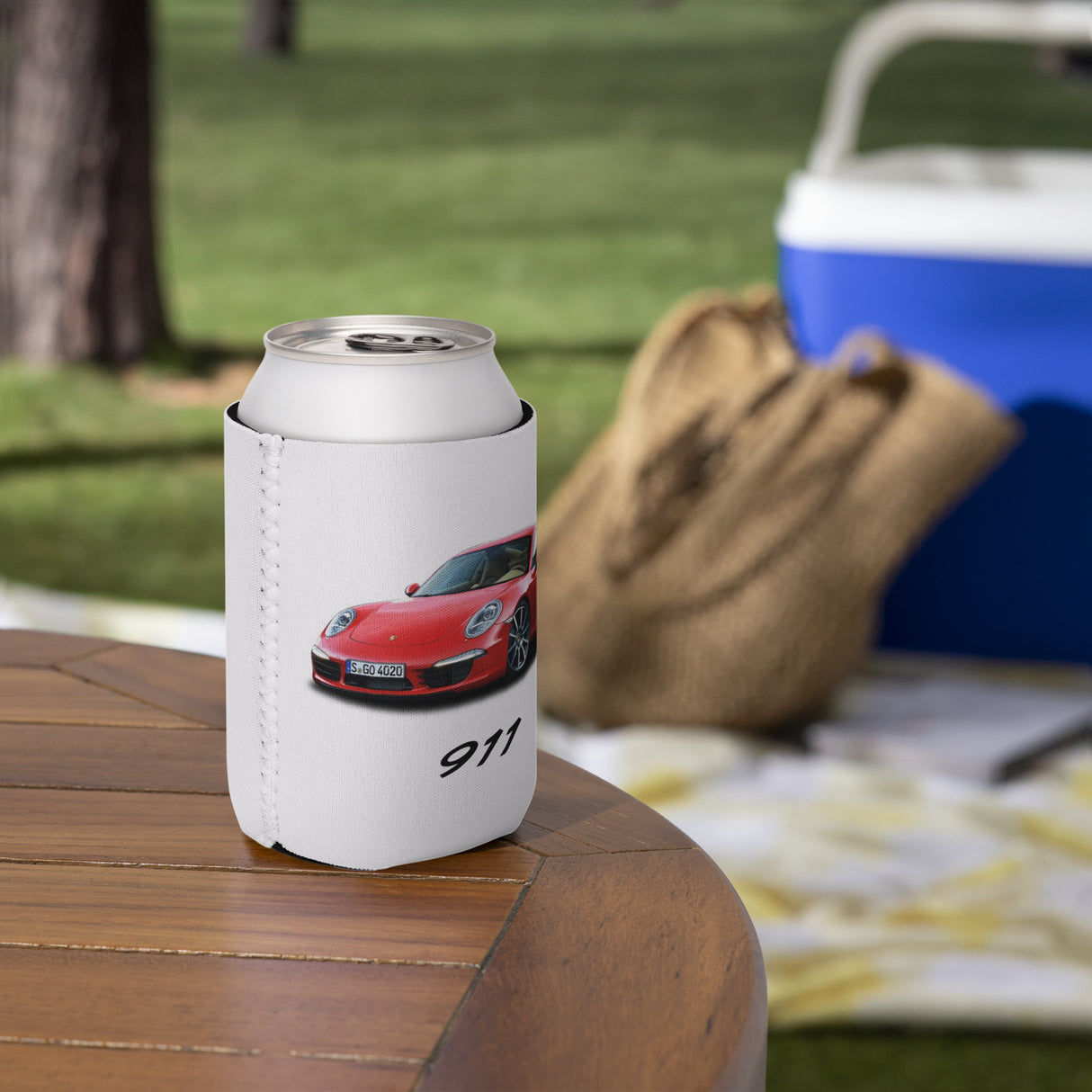 White can cooler with a red sports car design on a wooden table outdoors.