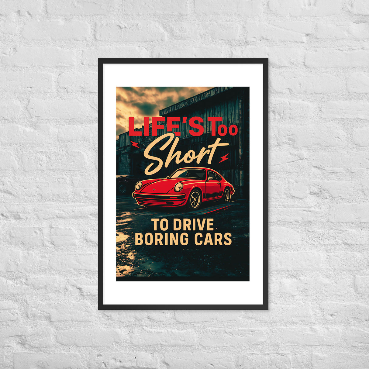 Framed Porsche 911 poster with bold text Life’s Too Short to Drive Boring Cars in red and cream on a dark background, displayed on a white brick wall.