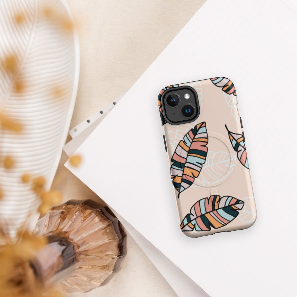 Phone case with colorful leaf design on a white surface