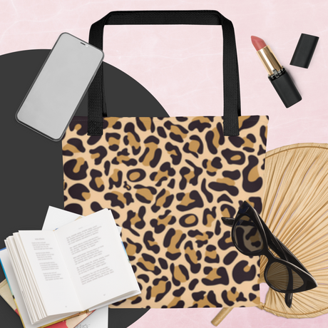 Leopard print tote bag with accessories on a pink background