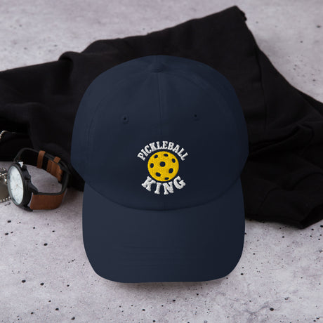 Navy dad hat embroidered with Pickleball King design, worn by man in plaid shirt