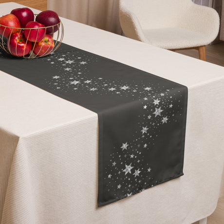Black table runner with star pattern on a white tablecloth, accompanied by a basket of apples.